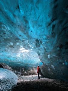 a person standing in front of an ice cave at Vagnsstadir in Borgarhöfn