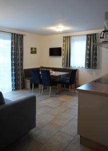 eine Küche und ein Esszimmer mit einem Tisch und Stühlen in der Unterkunft Appartements Fritzhof in Kirchberg in Tirol