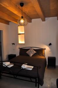 Bramante Suites Urbino في أوربينو: غرفة نوم بسرير اسود وسقف خشبي