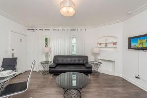 uma sala de estar com um sofá de couro e uma mesa em Courtyard Apartments Part of the Oasis Casita Collection em Miami Beach