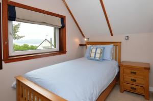 a bedroom with a bed and a window at Birch Cottage in Blairmore