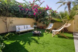 a garden with a couch and chairs and flowers at Frank Porter - Springs 12 in Dubai