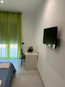 a room with a desk and a television on a wall at La casa dei Coloni in Nola