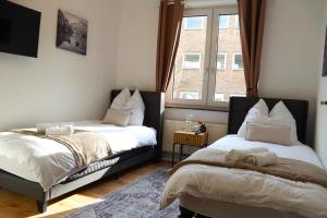 - une chambre avec 2 lits et une fenêtre dans l'établissement Timeless Apartment II Bremen-Neustadt, à Brême