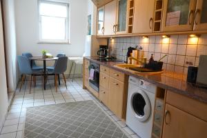 a kitchen with a washing machine and a table at Timeless Apartment II Bremen-Neustadt in Bremen