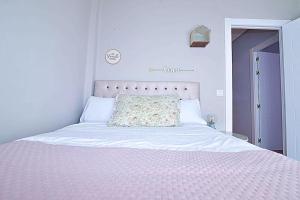 a bedroom with a white bed with a pink blanket at Apartamento con encanto "Las Raices" in Santander +52 photos
