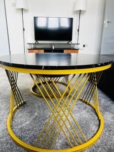 a yellow and black table in a room at Ivory Penthouse Next to Wembley Stadium by Imperia Stays in London