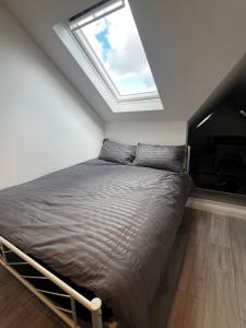 1 dormitorio con cama y ventana en Ivory Penthouse Next to Wembley Stadium by Imperia Stays en Londres