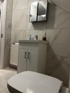 a bathroom with a toilet and a sink and a mirror at Ivory Penthouse Next to Wembley Stadium by Imperia Stays in London