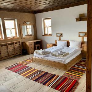 sypialnia z dużym łóżkiem i dywanem w obiekcie Family Hotel Byalata Kashta w mieście Kovachevitsa