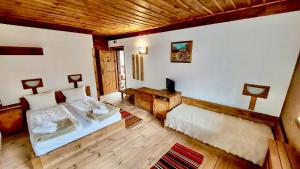1 dormitorio con cama y techo de madera en Family Hotel Byalata Kashta en Kovachevitsa