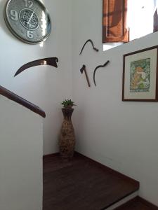una escalera con un jarrón y un reloj en la pared en Casale Crisanti en Beroide
