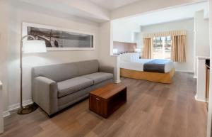 um quarto de hotel com uma cama e um sofá em The Point Hotel & Suites Universal em Orlando
