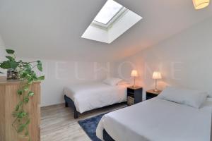 um quarto com 2 camas e uma clarabóia em Dépendance des Cigales em Saint-Cannat