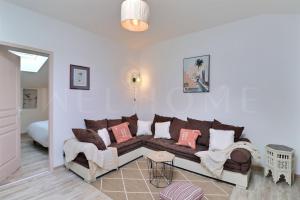 een woonkamer met een bruine bank en roze kussens bij Dépendance des Cigales in Saint-Cannat
