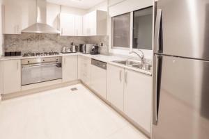 a kitchen with white cabinets and a stainless steel refrigerator at Frank Porter - Mon Reve in Dubai