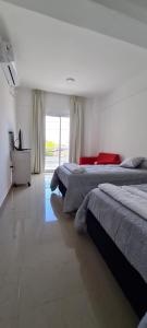 - une chambre avec 2 lits et une grande fenêtre dans l'établissement DELFINA suites 3A, à La Rioja