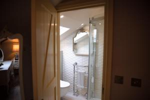 a bathroom with a shower with a toilet and a sink at The Stables in Longwitton