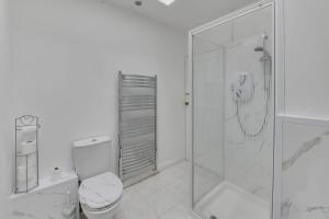 y baño blanco con ducha y aseo. en Remarkable 3-Bed House in Middleton Manchester en Mánchester