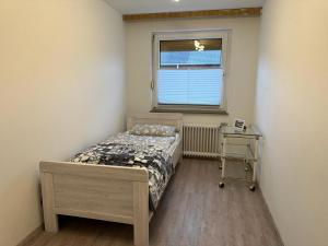 ein kleines Schlafzimmer mit einem Bett und einem Fenster in der Unterkunft Ferienhaus Morgenstern in Wilhelmshaven