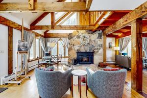 a living room with a stone fireplace and chairs at The Glengreen Retreat in Littleton