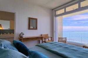 1 dormitorio con cama y vistas al océano en White Palm, en Paea