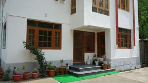 uma casa branca com vasos de plantas em frente em Green Resort em Rājbāgh