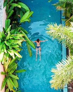 a woman in a swimming pool at a resort at Angam Villas Colombo in Colombo
