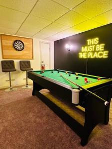 a pool table in a room with a wall with a sign at Private Riverfront Cottage in Muskoka - The MARA in Huntsville