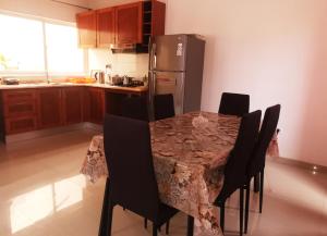 a kitchen with a table with chairs and a refrigerator at Miras Guest House in Praia