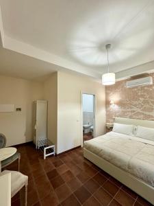 a bedroom with a bed and a table and a bathroom at La Magnolia 140 in Fiumicino