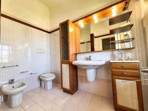 a bathroom with a sink and a toilet and a mirror at Villa sul tramonto in Castel di Tusa