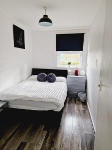 a bedroom with a bed with purple pillows on it at 2 Bedroom Cozy Chambers with free parking in Leeds