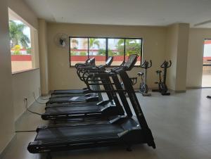 una fila de cintas de correr en un gimnasio con bicicletas en flats aconchegantes piscina e academia via park, en Campos dos Goytacazes