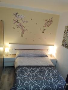 a bedroom with a bed with flowers on the wall at Apartamentos nova de abaixo 3, 1B 1A y 1D in Pontevedra