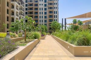 a walkway in a city with tall buildings at Frank Porter - Rahaal 2 in Dubai