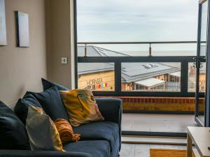 Wave Song في هورنسي: غرفة معيشة مع أريكة ونافذة كبيرة