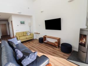 a living room with a couch and a flat screen tv at 8B Carrigreich in Tarbert