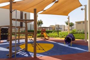 a playground with a canopy and a slide at Frank Porter - Urbana II in Dubai