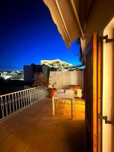 einen weißen Tisch auf dem Balkon eines Hauses in der Unterkunft Acropolis Plaka Ambience Retreat in Athen