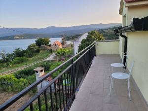 a balcony with two chairs and a view of the water at Mara village house in Vrlika