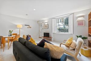 a living room with a couch and a table at Cosy, calm Camden Square studio in London