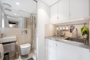 a white bathroom with a sink and a toilet at Cosy, calm Camden Square studio in London