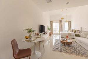 a white living room with a white couch and a table at Frank Porter - Canal Residence in Dubai