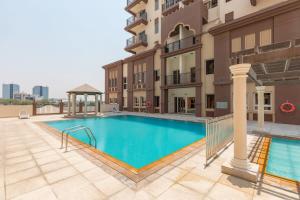 a swimming pool in front of a building at Frank Porter - Canal Residence in Dubai