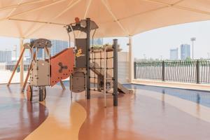 a playground on the roof of a building with a pool at Frank Porter - Canal Residence in Dubai