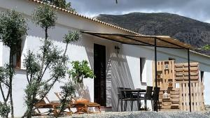 una casa blanca con una mesa y sillas frente a ella en Finca Valle Verde en Alora