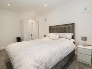 a bedroom with a large bed and a night stand at Seashell in Hornsea