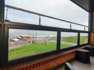 a window in a building with a view of the ocean at Seashell in Hornsea