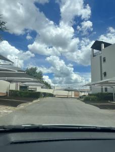 una vista desde un coche de una calle con edificios en Poppy Rentals, en Fourways